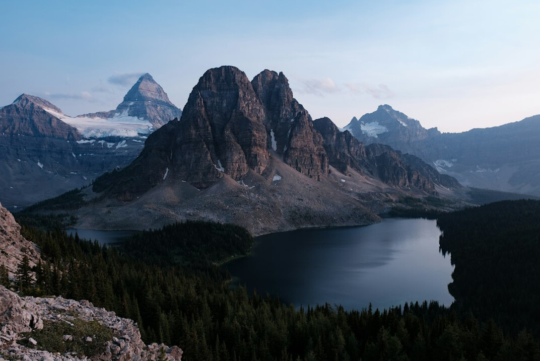 Sunrise over the jagged peaks of the Canadian Rockies with a turquoise lake below