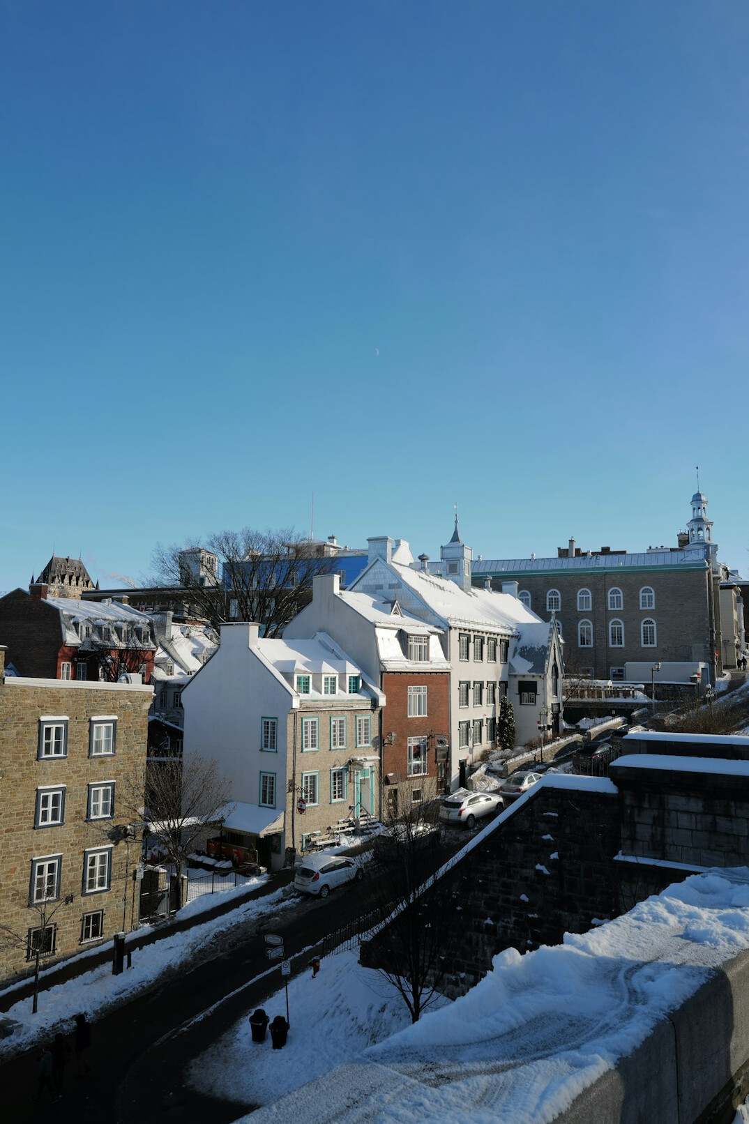 Snow covered cobblestone street in Old Quebec City lit by warm lamplight